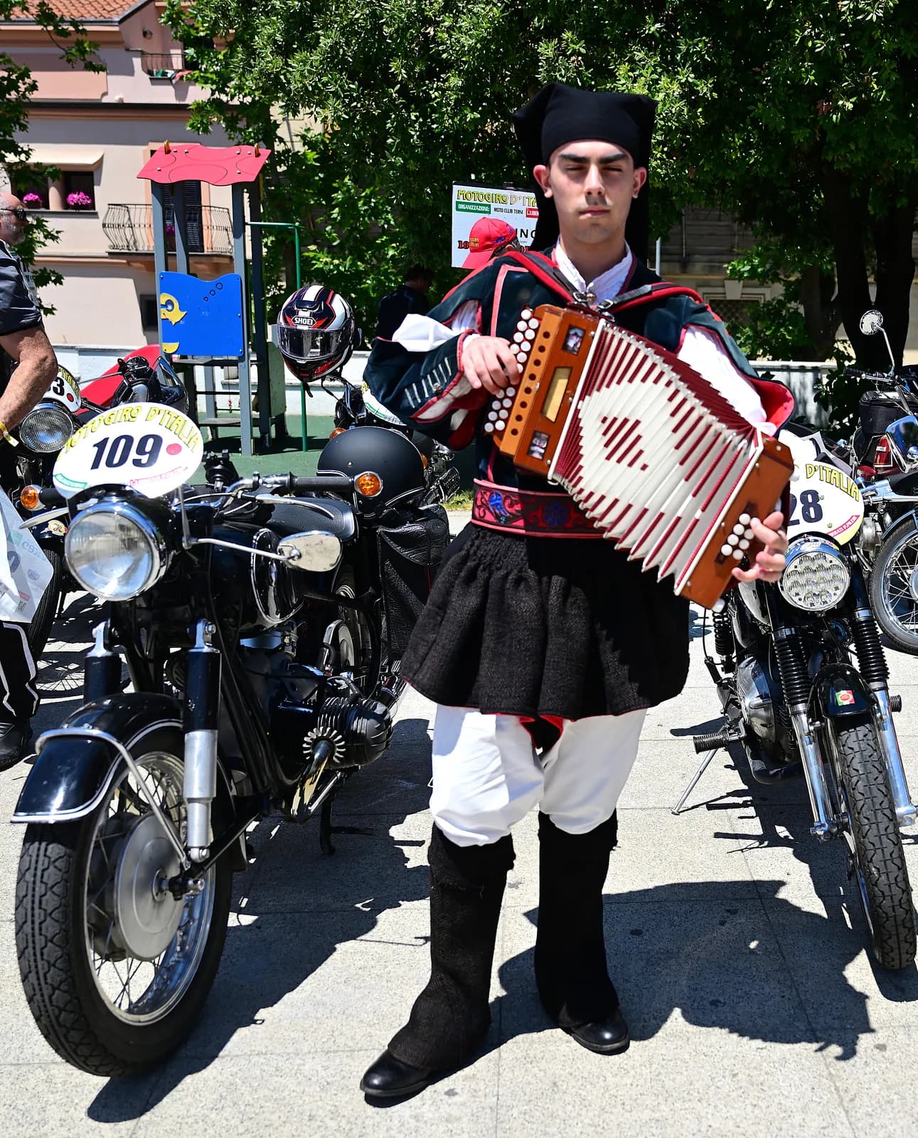 Musicista in costume tradizionale sardo accoglie le moto storiche
